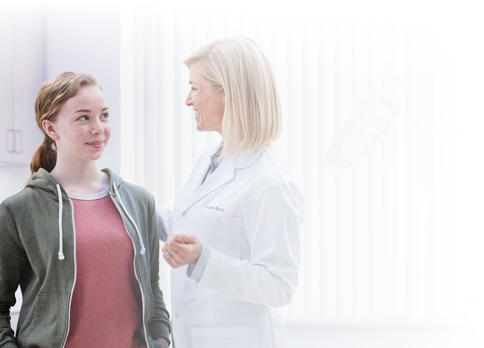 A young woman speaking with a doctor