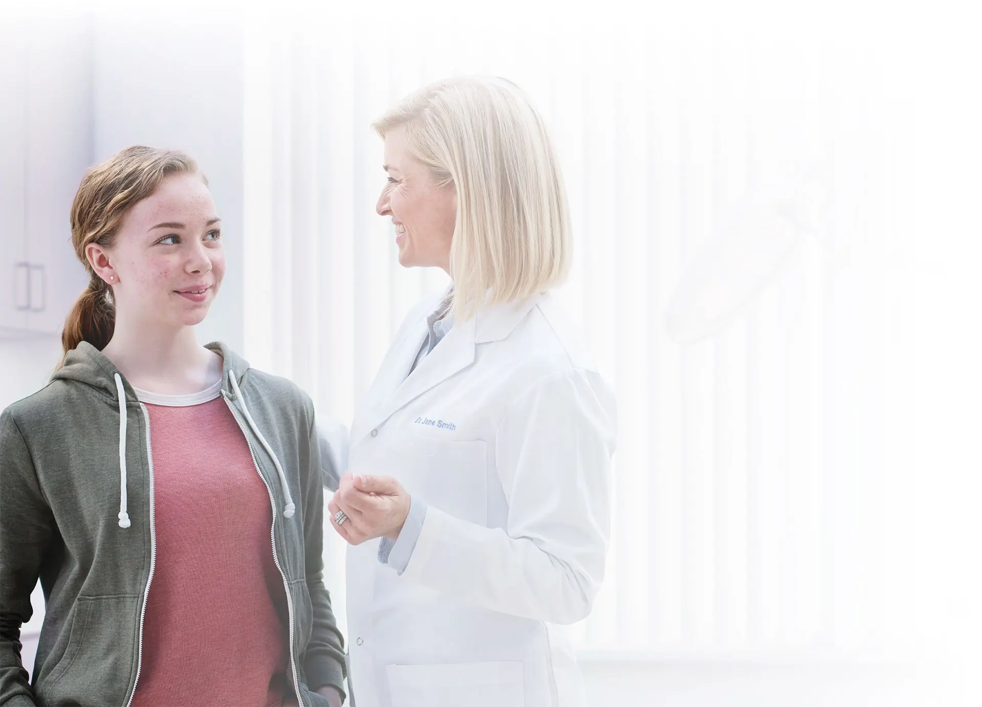 A young woman speaking with a doctor